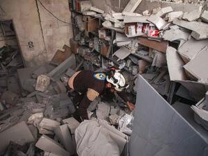 A member of the Syrian Civil Defence, also known as the "White Helmets", inspects through debris and rubble while searching for survivors at a destroyed hospital in the town of Darret Ezza, about 30 kilometres northwest of the northern Syrian city of Aleppo on February 17, 2020, after a reported air strike hit the building. AAREF WATAD / AFP