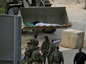 Israeli soldiers retrieve the body of a Palestinian in the village of Ras Karkar, near Ramallah in the occupied West Bank on February 17, 2020, reported to be the body of a man who wounded an Israeli soldier in a shooting attack ten days ago. ABBAS MOMANI / AFP