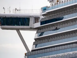 A passenger wearing a face mask looks out from the cabin of the Diamond Princess cruise ship, in quarantine due to fears of new COVID-19 coronavirus, at Daikoku pier cruise terminal in Yokohama on February 20, 2020. Two former passengers of the coronavirus-wracked Diamond Princess have died, local media reported, as fears mount about those who have left the ship after testing negative for the virus. Philip FONG / AFP