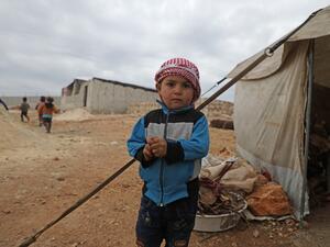  Syrian boy stands outside a tent at an informal camp in Kafr Lusin village on the border with Turkey in Syria's northwestern province of Idlib, on February 21, 2020. AFP