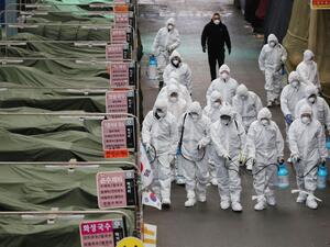 Market workers wearing protective gear spray disinfectant at a market in the southeastern city of Daegu on February 23, 2020 as a preventive measure after the COVID-19 coronavirus outbreak. AFP