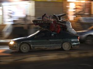 Displaced Syrians drive a car loaded with their belongings through the town of Atme, near the Turkish border in the northwestern Idlib province, on February 23, 2020. Rami al SAYED / AFP