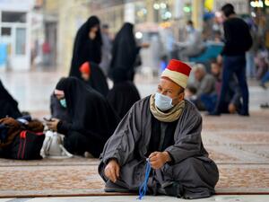 Worshippers wearing masks sit in the courtyard of the shrine of Imam Ali on February 25, 2020 in the holy Iraqi central city of Najaf, where the first case of coronavirus COVID-19 has been documented in Iraq. Iraq on February 24 confirmed its first novel coronavirus case in an elderly Iranian national in Najaf, according to health officials. A country with a dilapidated healthcare system, Iraq often hosts pilgrims and religious students from Iran, where at least a dozen people have died of the novel coronav
