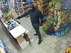 The man, who was seen wearing a balaclava, entered the shop before pulling out a gun and approaching the woman as she mopped the floors. (Video Screenshot)