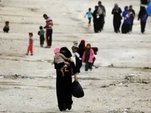 People walk through Ain Issa, one of the camps that holds displaced Syrians as well as foreign wives of ISIS fighters and their children. AFP