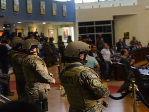 عسكريون مسلحون ببنادق ويرتدون سترات واقية من الرصاص يقتحمون مقر البرلمان