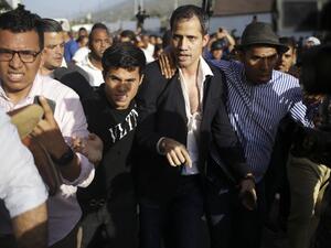 Venezuelan opposition leader and self-proclaimed acting president Juan Guaido is escorted to his car after arriving at Simon Bolivar International Airport in Maiquetia, Vargas state, Venezuela on February 11, 2020. (AFP)