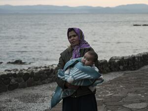 A migrant woman carries a toddler near Skala Sykamineas on the Greek Lesbos island after crossing the Aegean sea between Turkey and Greece on March 01, 2020. Greece has blocked nearly 10,000 migrants trying to enter at the Turkey border over the past 24 hours, a Greek government source said Sunday. "From 0600 (0400 GMT) Saturday morning to 0600 Sunday morning, 9,972 illegal entrances have been averted in the Evros area," a government source said, referring to the northeastern region along the Turkey border.