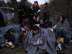 Migrants sit on a beach covered with blanket near Skala Sykamineas on the Greek Lesbos island after crossing the Aegean sea between Turkey and Greece on March 1, 2020. Greece has blocked nearly 10,000 migrants trying to enter at the Turkey border over the past 24 hours, a Greek government source said Sunday. "From 0600 (0400 GMT) Saturday morning to 0600 Sunday morning, 9,972 illegal entrances have been averted in the Evros area," a government source said, referring to the northeastern region along the Turk