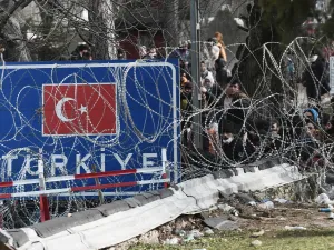 This picture taken from the Greek side of the Greece-Turkey border near Kastanies, shows migrants waiting on the Turkish side on March 2, 2020. Greece was on a state of alert on March 1, 2020 as it faced an influx of thousands of migrants seeking to cross the border from Turkey, with locals fearing a new immigration crisis. More than 13,000 migrants have gathered on the Turkish side of the river which runs 200 kilometres (125 miles) along the frontier and separates them from Greece and therefore the Europea