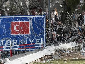 This picture taken from the Greek side of the Greece-Turkey border near Kastanies, shows migrants waiting on the Turkish side on March 2, 2020. Greece was on a state of alert on March 1, 2020 as it faced an influx of thousands of migrants seeking to cross the border from Turkey, with locals fearing a new immigration crisis. More than 13,000 migrants have gathered on the Turkish side of the river which runs 200 kilometres (125 miles) along the frontier and separates them from Greece and therefore the Europea