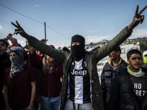 Migrants and refugees take part in a demonstration following clashes with Greek riot police near the Moria camp for refugees and migrants on the island of Lesbos on March 2, 2020. More than 13,000 migrants have gathered on the Turkish side of the river which runs 200 kilometres (125 miles) along the frontier and separates them from Greece and therefore the European Union. The flow of migrants from Turkey has triggered EU fears of a re-run of the 2015 migrant emergency when Greece became the main EU entry po