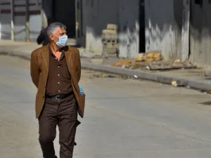 An Iraqi man wearing a protective mask walks in a deserted street in the northern Iraqi city of Mosul on March 3, 2020 amid fears of the spread of the coronavirus across Iraq. Iraq reported its first coronavirus case last week in an Iranian national studying at a religious seminary in the southern shrine city of Najaf. The total number of diagnosed infections has since jumped to 19 -- all traced to the Islamic republic, just across the border. This has sparked public panic in Iraq, one of Iran's largest exp