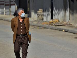 An Iraqi man wearing a protective mask walks in a deserted street in the northern Iraqi city of Mosul on March 3, 2020 amid fears of the spread of the coronavirus across Iraq. Iraq reported its first coronavirus case last week in an Iranian national studying at a religious seminary in the southern shrine city of Najaf. The total number of diagnosed infections has since jumped to 19 -- all traced to the Islamic republic, just across the border. This has sparked public panic in Iraq, one of Iran's largest exp
