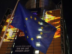 The European Union flag flies in front of images projected by activists from the environmental group Greenpeace showing Earth on fire onto the European Commission headquarters during a protest action on the eve of the presentation of the European Union climate law, in Brussels, on March 3, 2020. The EU Commission is due to introduce on March 4, 2020, its proposal for a "Climate Law" on climate neutrality in 2050. kenzo tribouillard / AFP