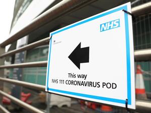 A sign directs directs patients to an NHS 111 Coronavirus Pod testing service area for COVID-19 assessment at University College Hospital in London on March 5, 2020. The number of confirmed cases of novel coronavirus COVID-19 in the UK rose to 85 on March 4, with fears over the outbreak delaying the global release of the new James Bond movie and causing lack of demand for air travel that has proved the final nail in the coffin for British regional airline Flybe which went into administration on March 5.  IS