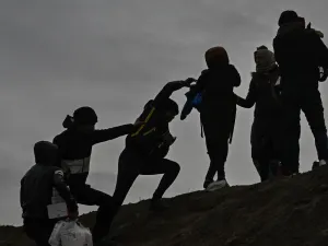 Migrants climb a hill as they gather near the Tunca river in the city of Edirne, northwest Turkey on March 5, 2020 waiting to resume their efforts to enter Europe near Pazarkule border gate. EU members on March 4, 2020 rejected what they said is Turkey's use of desperate migrants to pressure its neighbours -- and strongly backed Greece's border crackdown. The EU has scrambled to respond to the surge of migrants at the Greek border, where authorities say some 24,000 were stopped from entering between Februar