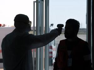 The body temperature of an Iraqi passenger returning from Iran is measured upon arrival at Najaf International Airport on March 5, 2020. Iraqi health authorities announced the country's first two deaths from the new coronavirus, one in the capital Baghdad and the other in the autonomous Kurdish region. Haidar HAMDANI / AFP