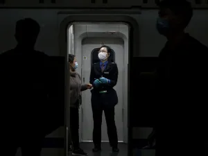 A train attendant wearing a facemask as a preventive measure against the spread of the COVID-19 coronavirus assists a passenger at the Changsha railway station in Changsha, the capital of Hunan province on March 5, 2020. More than 95,000 people have been infected and over 3,200 have died worldwide from the new coronavirus, which by on March 5 had reached some 80 countries and territories. Noel CELIS / AFP