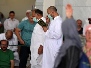 Worshippers, some of them wearing protective masks, take part in the Friday prayers in front of Mecca's Grand Mosque on March 6, 2020, a day after Saudi authorities emptied Islam's holiest site for sterilisation over fears of the new coronavirus COVID-19, an unprecedented move after the kingdom suspended the year-round umrah pilgrimage. Abdel Ghani BASHIR / AFP