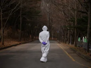 A health worker wearing a protective suit waits at a drive-through testing centre for the COVID-19 coronavirus in Seoul on March 7, 2020. South Korea has the biggest number of COVID-19 coronavirus cases outside China, with over 6,000 infections and 42 deaths, prompting the country to extend school breaks by three weeks. Ed JONES / AFP