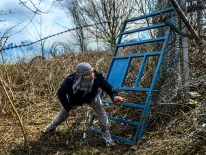 A migrant tries to breack fences near the Pazarkule crossing gate of the Turkey-Greece border on March 7, 2020 in the province of Edirne where makeshift camps have sprung up around the border as thousands of refugees have been encouraged by Turkey to leave for the European Union, in a bid to gain Western backing in Syria. AFP/File