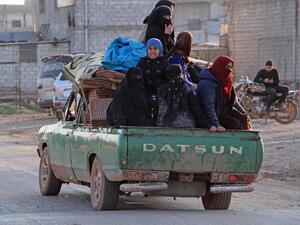Syrians ride in the back of a truck in the town of Hazano in the rebel-held northern countryside of Syria's Idlib province on March 7, 2020. Ibrahim YASOUF / AFP