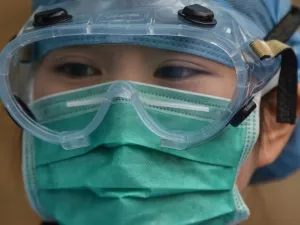 A medical worker wearing protective clothing as a preventive measure against the COVID-19 coronavirus, stands at Xuhui District Hospital in Shanghai on March 9, 2020 China reported 22 new deaths on March 9 from the new coronavirus epidemic, and the lowest number of fresh cases since it started reporting the data in January. Hector RETAMAL / AFP