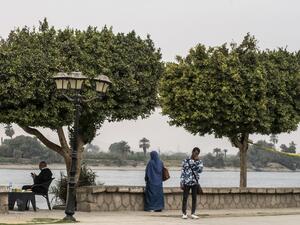 A picture take on March 11, 2020 shows an Egyptian police officer (L) sitting on the shore of the Nile river in Egypt's southern city of Luxor. Egyptian authorities said that 46 French and US tourists who had been quarantined on a coronavirus-hit Nile cruise boat have flown home. They were among dozens of foreign tourists and Egyptian crew who had been either confined to the vessel or hospitalised after an outbreak of the virus.  Khaled DESOUKI / AFP