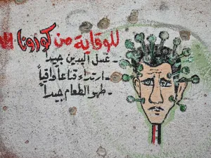 A graffiti portraying President Bashar al-Assad as the coronavirus is seen on the wall of a destroyed school in Binnish town in Syria’s northwestern Idlib province near the Turkish border, on March 10, 2020. AFP/File