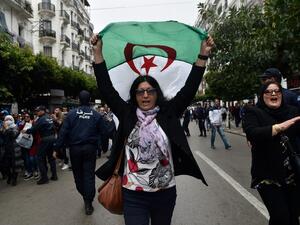 An Algerian woman waves a national flag as she takes part in an anti-government demonstration in the capital Algiers on March 14, 2020. RYAD KRAMDI / AFP