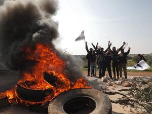 Syrians protest and burn tyres in an attempt to block traffic on the M4 highway, which links the northern Syrian provinces of Aleppo and Latakia, before incoming joint Turkish and Russian military patrols (as per an earlier agreed upon ceasefire deal) in the village of al-Nayrab, about 14 kilometres southeast of the city of Idlib and seven kilometres west of Saraqib in northwestern Syria on March 15, 2020. AFP/File