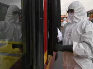A worker washes and disinfects a bus at the bus station, as a measure to prevent the spread of the new Coronavirus, COVID-19, in Bogota, Colombia, on March 15, 2020. AFP/File