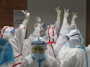Medical staff cheer themselves up before going into an ICU ward for COVID-19 coronavirus patients at the Red Cross Hospital in Wuhan in China's central Hubei province on March 16, 2020. China reported 12 more imported cases of the novel coronavirus on March 16 as the capital tightened quarantine measures for international arrivals to prevent a new wave of infections. STR / AFP