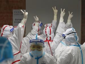 Medical staff cheer themselves up before going into an ICU ward for COVID-19 coronavirus patients at the Red Cross Hospital in Wuhan in China's central Hubei province on March 16, 2020. China reported 12 more imported cases of the novel coronavirus on March 16 as the capital tightened quarantine measures for international arrivals to prevent a new wave of infections. STR / AFP