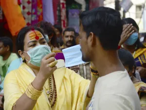 A member of the transgender community distributes free facemask amid concerns over the spead of the COVID-19 coronavirus, at a market area in Allahabad on March 19, 2020. SANJAY KANOJIA / AFP
