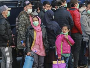 Migrants arrive at the port of Mytilene in the Greek island of Lesbos on March 20, 2020 to be transfered in a closed camp in northern Greece as the country is battling hard to control the novel coronavirus that causes COVID-19 infection and also racing to avoid contagion among tens of thousands of migrants in overcrowded camps nationwide, a situation recently termed a "health bomb" by government spokesman. Manolis Lagoutaris / AFP