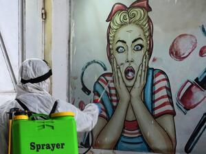 A volunteer disinfects a shop in Baghdad's Bayaa neighbourhood on March 21, 2020 as a preventive measure against the spread of the coronavirus COVID-19. AHMAD AL-RUBAYE / AFP