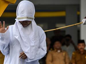 Dozens gathered to watch as the humiliated woman was whipped along with seven other victims outside a mosque in the provincial capital Banda Aceh (AFP)