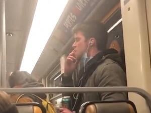 He then lifts his right hand up to his mouth and licks his fingers while eyeing the vertical Brussels subway rail in front of him  (Twitter)