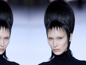 Bella took to the runway in a black form-fitting polo neck and satin pleated culottes