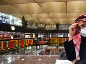 A Kuwaiti trader wearing a protective mask follows the market at the Boursa Kuwait stock exchange in Kuwait City, March 1, 2020. (Yasser al-Zayyat/AFP)