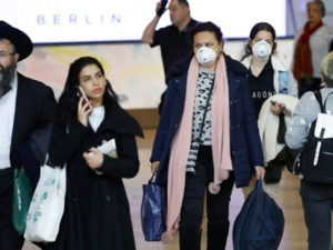 Israeli Passengers wearing protective masks in the arrivals halls at Ben Gurion International Airport near Tel Aviv on March 10, 2020. (Jack Guez/AFP)