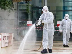 An Israeli firefighter sprays disinfectant at the entrance of Ichilov Hospital in Tel Aviv on March 20, 2020. (Jack Guez/AFP)