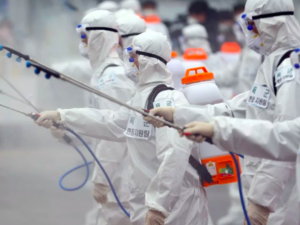 South Korean soldiers wearing protective gear spray disinfectant as part of preventive measures against the spread of the COVID-19 coronavirus, at Dongdaegu railway station in Daegu. -YONHAP/AFP
