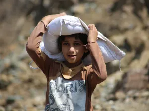 Children and women their food and drink needs through rugged mountain roads because of Al-Houthi militia siege of the villages of Jabal Habashi District in the west of Taiz. (Shutterstock/ File Photo)