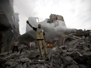 A Palestinian man stands amid debris following an Israeli air strike in Gaza City on July 11. (Photo: Mohammed Abed / AFP / Getty Images)