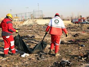 Rescue teams recover a body after a Ukrainian plane carrying 176 passengers crashed near Imam Khomeini airport in the Iranian capital Tehran on January 8, 2020, killing everyone on board. (AFP)