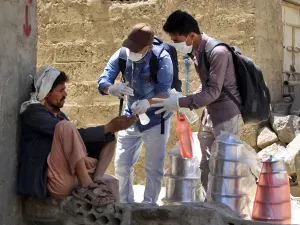 Yemeni volunteers spray disinfectant on the hands of a man in the one of Sanaa's impoverished neighbourhoods, on March 30, 2020, amid concerns of a coronavirus outbreak. MOHAMMED HUWAIS / AFP