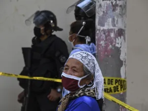 An elderly woman wears a face mask against the spread of the new coronavirus as he queues to enter a bank in San Salvador on March 30, 2020. Thousands of Salvadorans in different parts of the country were desperately seeking to receive the aid of $300 from the government for the purchase of food Monday during the outbreak of the new coronavirus pandemic.  Yuri CORTEZ / AFP